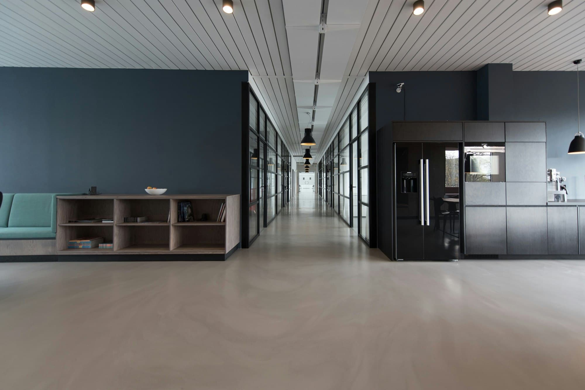 A calm, minimal modern office corridor with glass partitions